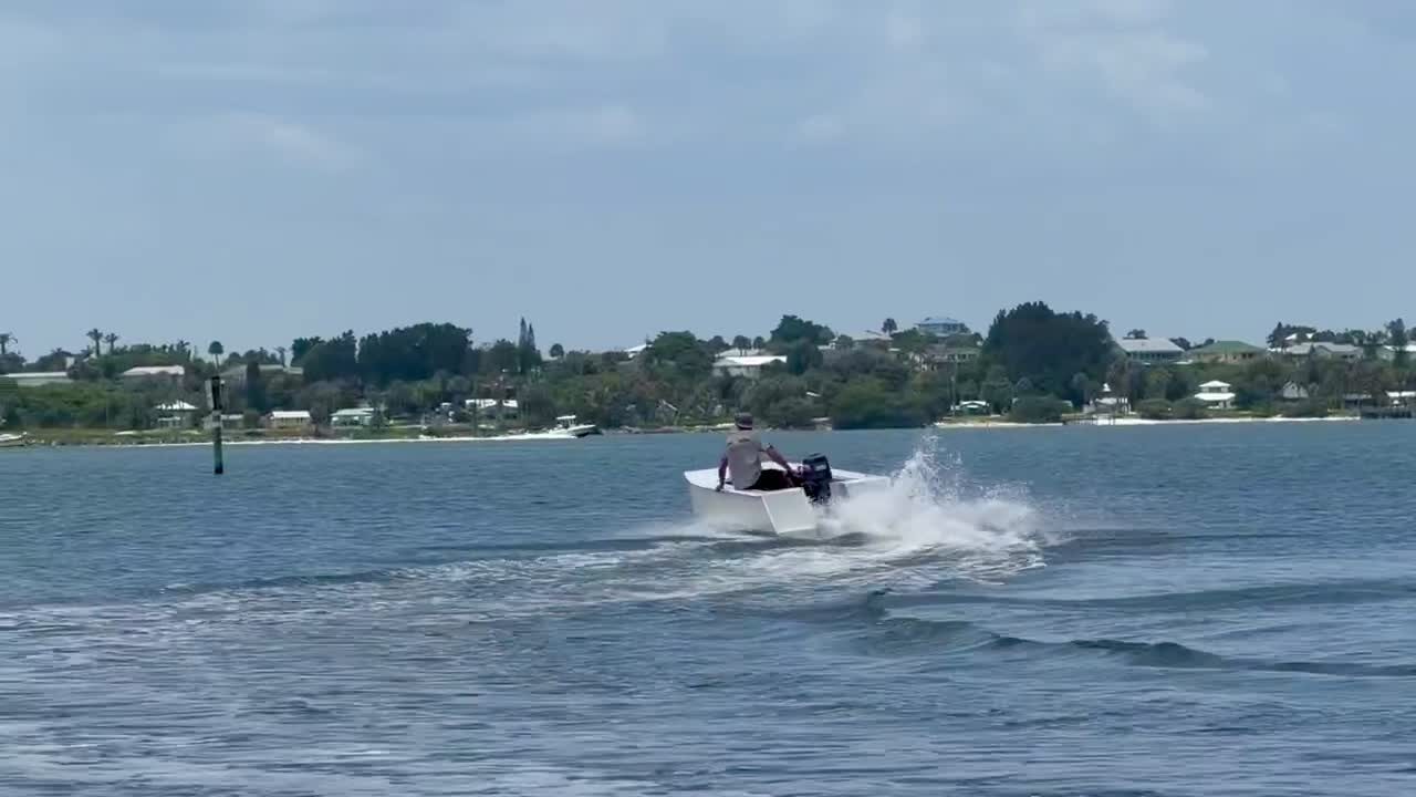 A Cape Cat 115 running at speed past the shoreline